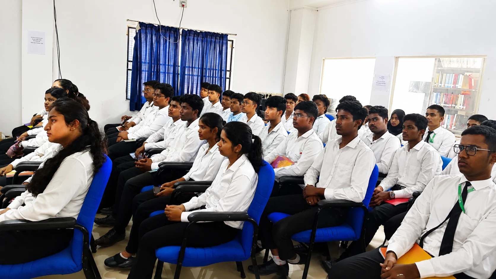 Uniformed college students seated in rows during a session